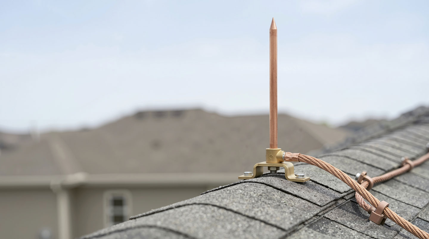 Professional installation of copper air terminals and down conductors on commercial building rooftop showing proper spacing, mounting hardware, and earth termination connections